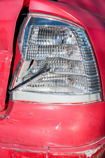 A close up of a broken light on a red car
