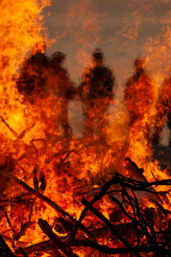 Burning branches and people silhouettes