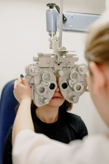 A person looks through an eye testing machine.