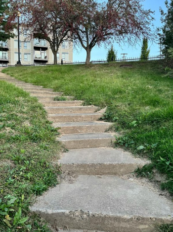 A pathway up a hill towards an apartment building