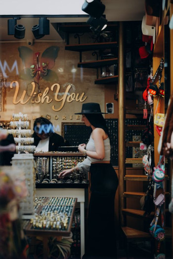 A woman in a cowboy hat stands shopping in a jewellery shop.