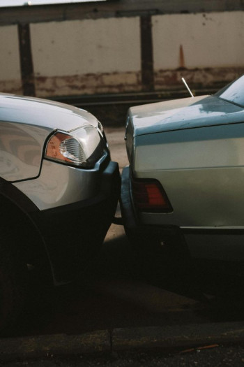 A close up of a minor nose-to-tail car crash between two silver cars.