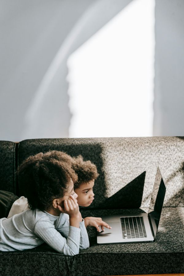 2026 children lying on a couch watching a screen